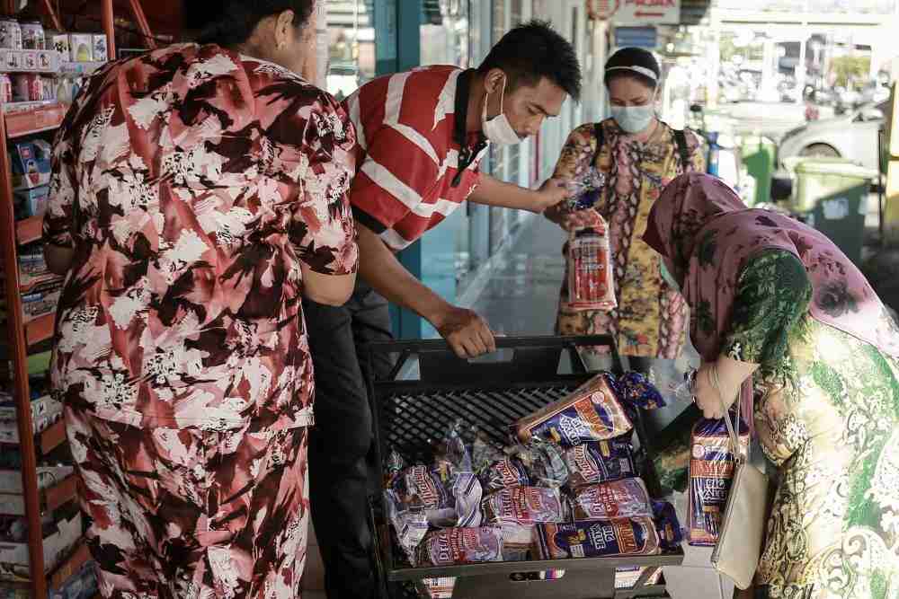 A Gardenia staff member unpacks fresh loaves of bread at a convenience store in Petaling Jaya March 25, 2020. u00e2u20acu201d Picture by Ahmad Zamzahuri
