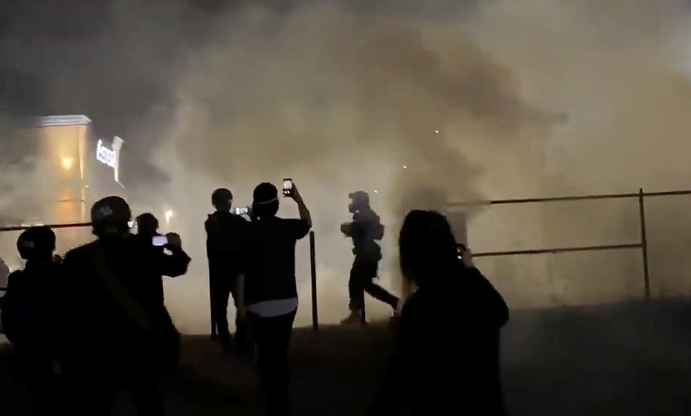 A police officer runs among tear gas as people protest in the aftermath of the death in Minneapolis police custody of George Floyd, in Portland June 30, 2020. u00e2u20acu201d TWITTER/ @GRAVEMORGAN image via Reuters