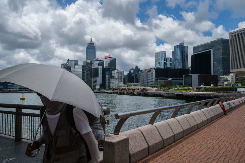 A man walks with his child past a view of commercial buildings and the government headquarters in Hong Kong July 16, 2020. u00e2u20acu201d AFP pic 