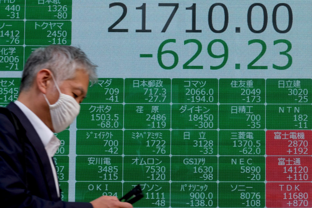 A pedestrian walks past an electronic quotation board displaying share prices from the Tokyo Stock Exchange in Tokyo July 31, 2020. u00e2u20acu201d AFP pic 