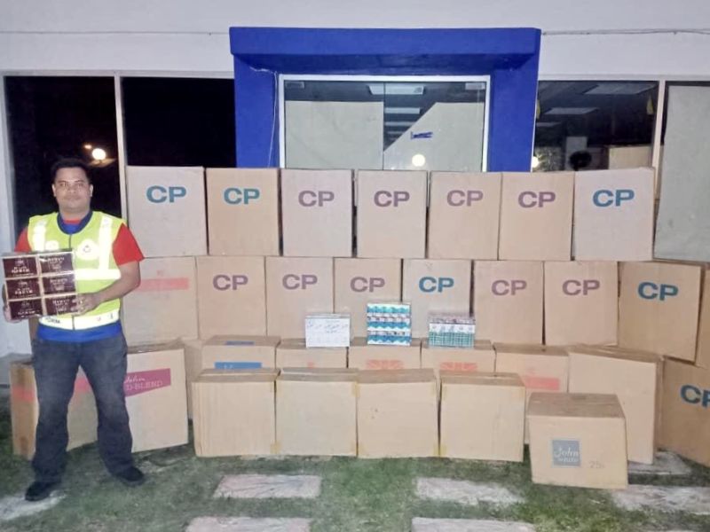 A policeman with the seized contraband cigarettes at the Batu Pahat district police headquarters after a raid on the Parit Yaani premises. u00e2u20acu201d Picture courtesy of the Johor marine police force