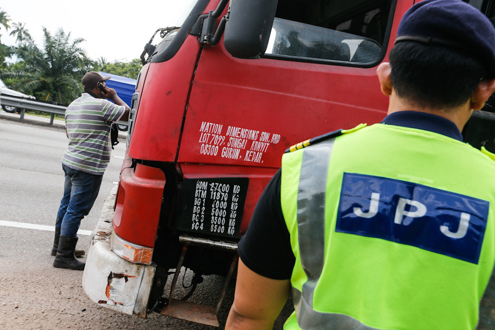 A Road Transport Department officer checks a lorry believed to be breaking the rules on transporting goods at Sungai Dua, Penang, July 21, 2020. u00e2u20acu201d Picture by Sayuti Zainudin