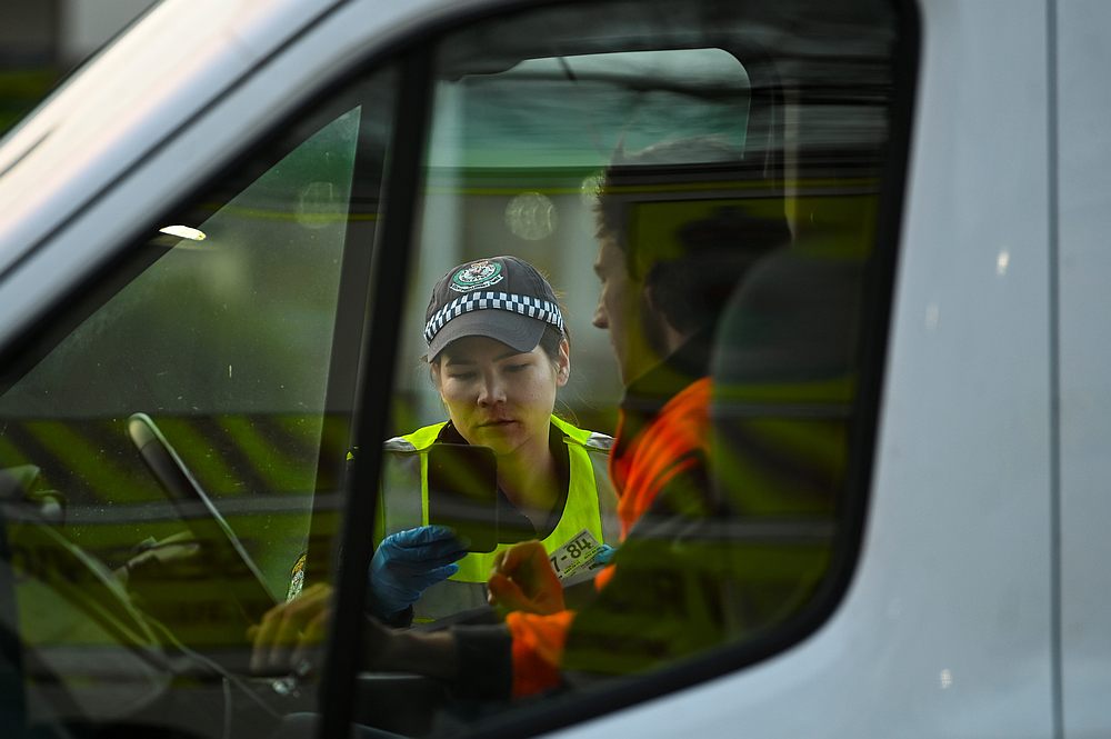 A NSW police officer checks a driver's permit as he crosses from the state of Victoria into New South Wales (NSW) at a border check point in Albury, New South Wales, Australia July 8, 2020. u00e2u20acu201d AAP Image via Reuters