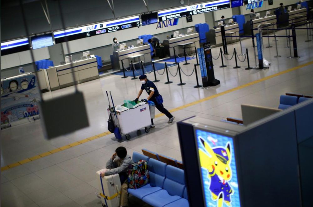 An employee wearing protective mask works at the almost empty Kansai International Airport in Osaka, Japan on March 14, 2020. u00e2u20acu201d Reuters pic