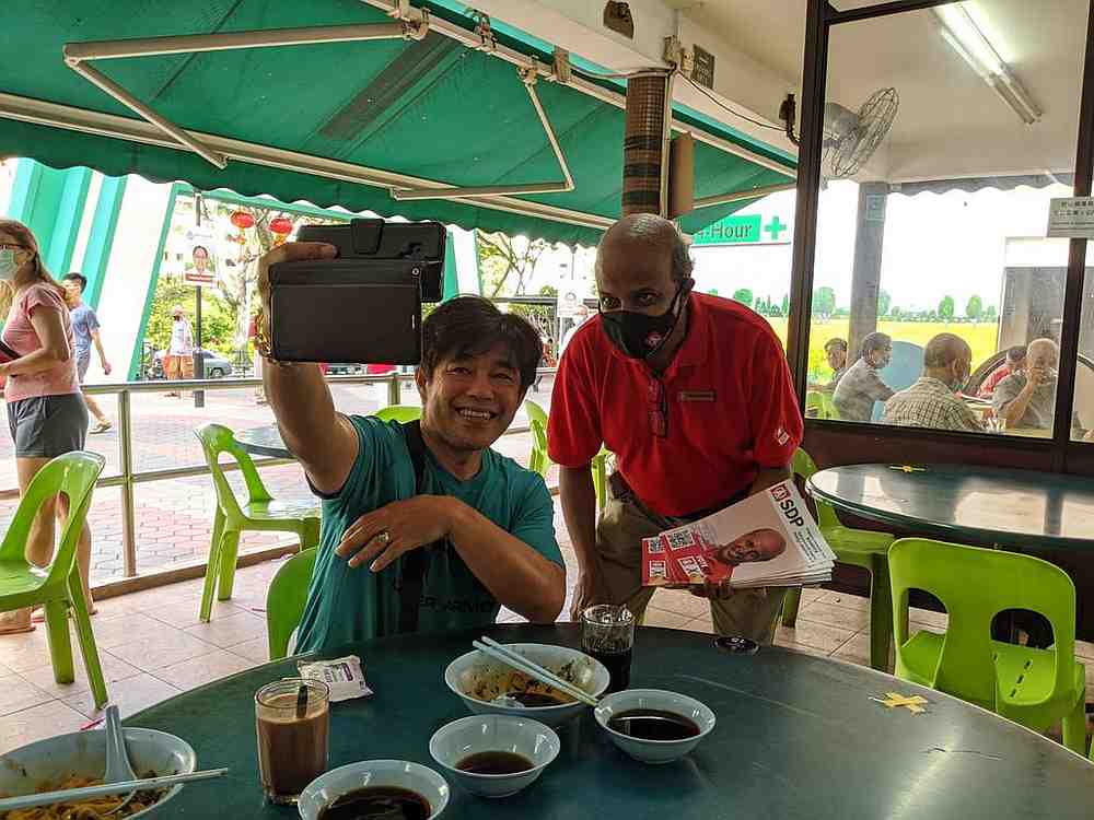 Paul Tambyah (right) from the Singapore Democratic Party taking a selfie with a resident of Bukit Panjang during a walkabout July 4, 2020. u00e2u20acu201d TODAY pic