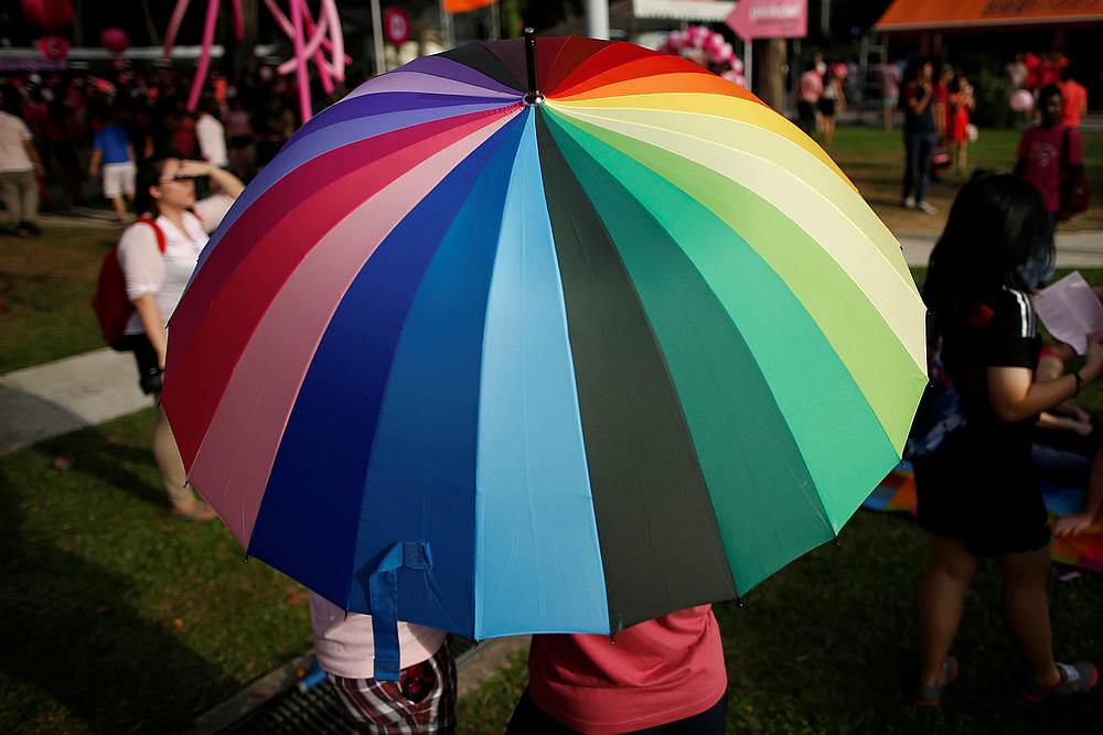 Participants shield themselves from the sun under a rainbow-coloured umbrella before taking part in the forming of a giant pink dot at the Speakers' Corner in Hong Lim Park in Singapore June 28, 2014. u00e2u20acu201d Reuters pic