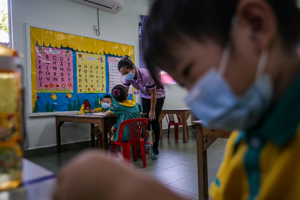 Preschoolers are seated accordingly to maintain social distancing while a teacher conducts a class at Mayter Kindergarten in Cheras July 1, 2020. u00e2u20acu201d Picture by Hari Anggara