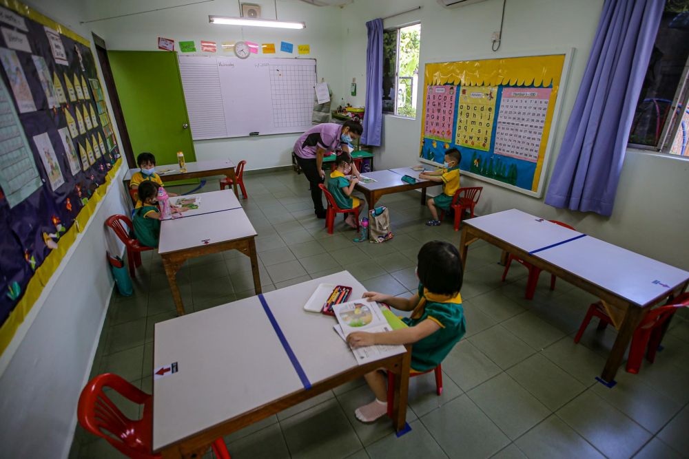 Preschoolers are seated accordingly to maintain social distancing while a teacher conducts a class at Mayter Kindergarten in Cheras July 1, 2020. u00e2u20acu201d Picture by Hari Anggara