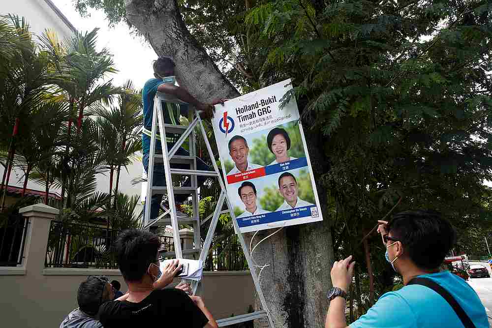 Workers hang an electoral poster on a tree at a neighbourhood ahead of the general election in Singapore June 30, 2020. u00e2u20acu201d Reuters pic