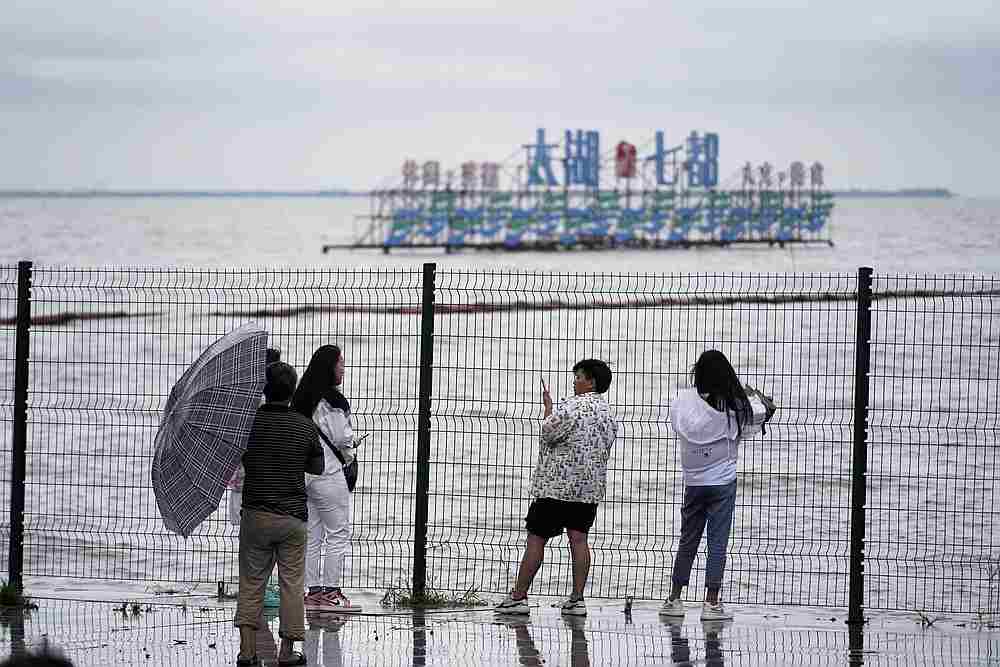 People stand by the Tai Lake, which has flooded its banks following heavy rainfall, in Huzhou, Zhejiang province, China July 15, 2020. u00e2u20acu201d Reuters pic