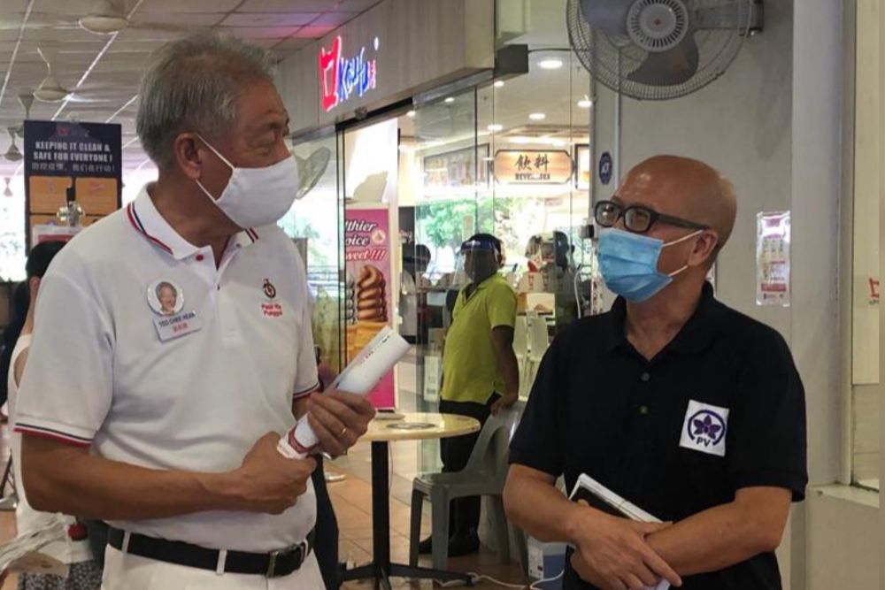 PAP’s Teo Chee Hean (left) and Peoples Voice’s Gilbert Goh chat at the Koufu food court at Punggol Plaza. Both party’s teams met while handing out flyers for Pasir-Ris Punggol GRC, July 1, 2020. — Picture by Louisa Tang/TODAY