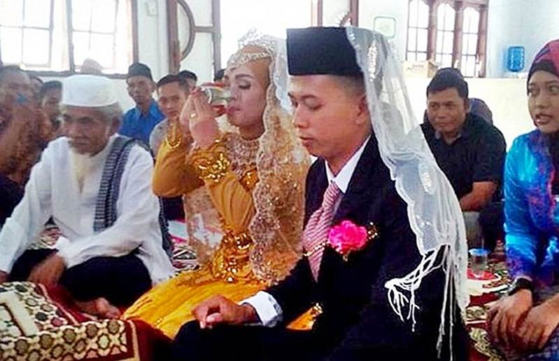 Helmi drinks her dowry gift as the couple tie the knot. — Picture courtesy of Facebook/Purwanto