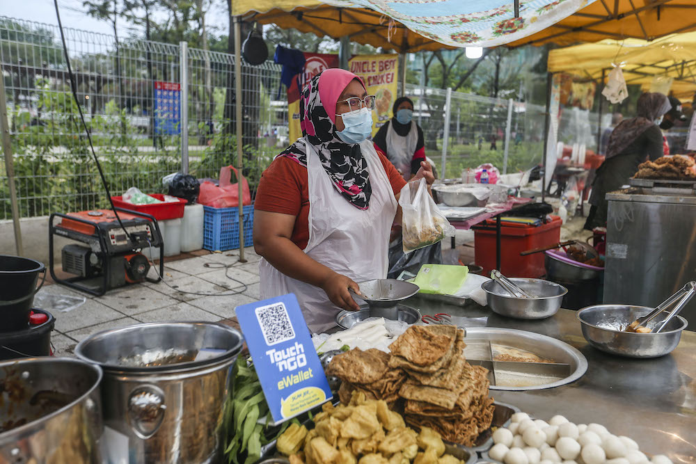 A vendor displays an e-wallet acceptance board at her stall in Setapak August 15, 2020. — Picture by Firdaus Latif 