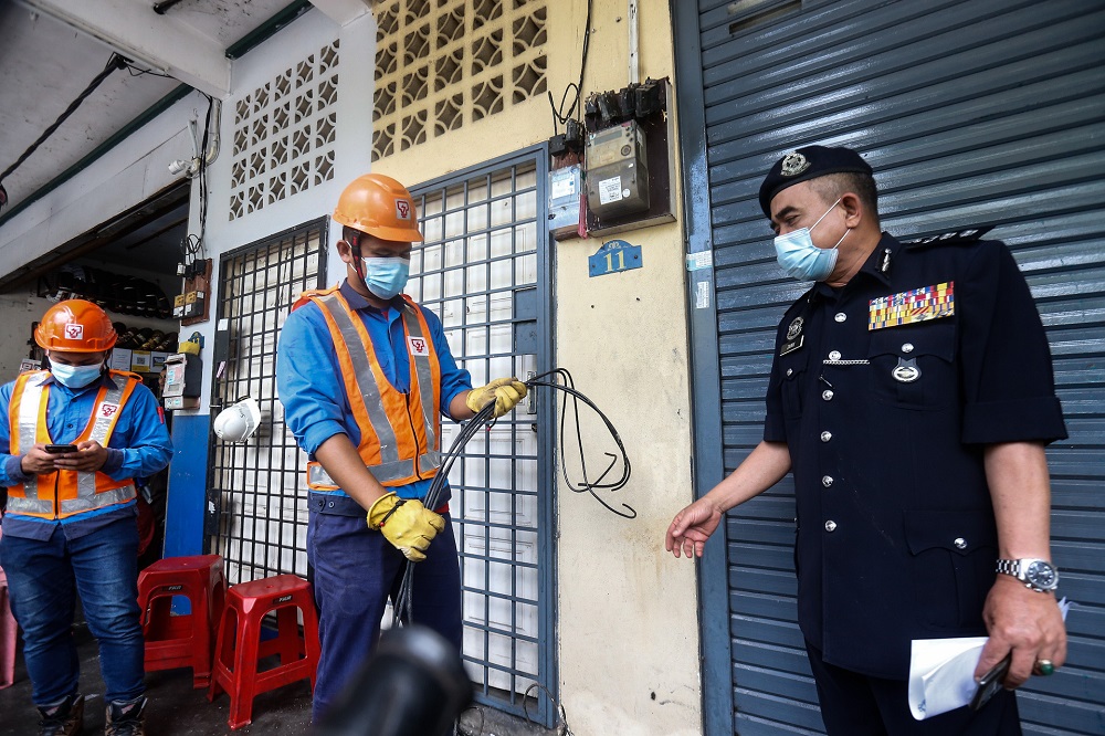 Tenaga National Berhad personnel cut the main power line to a shoplot that runs an illegal gambling den here at Bertam Putra, Kepala Batas August 13, 2020. —  Picture by Sayuti Zainudin