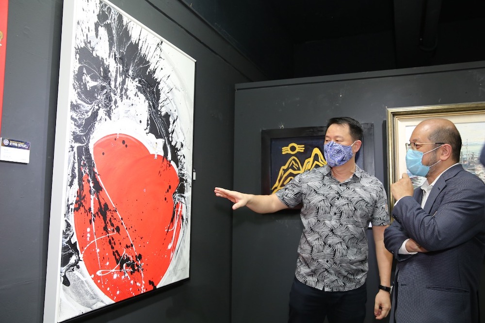 Penang Art Society President Chu00e2u20acu2122ng showing his latest artwork to Penang State Art Gallery Chairman Lee Khai (right). u00e2u20acu201d Picture courtesy of Penang Art Societyn