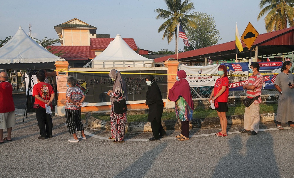 People are seen practising social distancing while waiting in line to cast their ballots at the Sekolah Kebangsaan Aminnudin Baki polling station in Slim River August 29, 2020. u00e2u20acu201d Picture by Farhan Najib