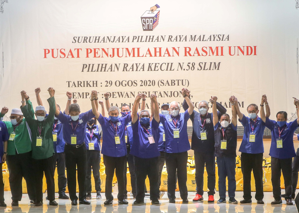 BN candidate Mohd Zaidi Aziz (centre) celebrates with coalition leaders and supporters at Dewan Sri Tanjung in Tanjung Malim after retaining the state seat in the Slim by-election August 29, 2020. u00e2u20acu201d Picture by Farhan Najib