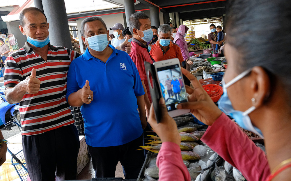 BNu00e2u20acu2122s Mohd Zaidi Aziz takes photos with members of the public while visiting the morning market at Slim River market, August 20, 2020. u00e2u20acu201d Bernama pic