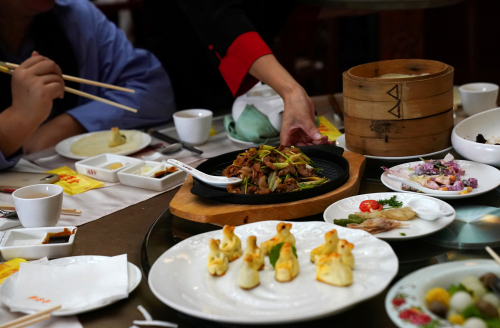 A waitress serves dishes for customers at the Quanjude Peking roast duck restaurant in Beijing, China August 18, 2020. — Reuters pic 