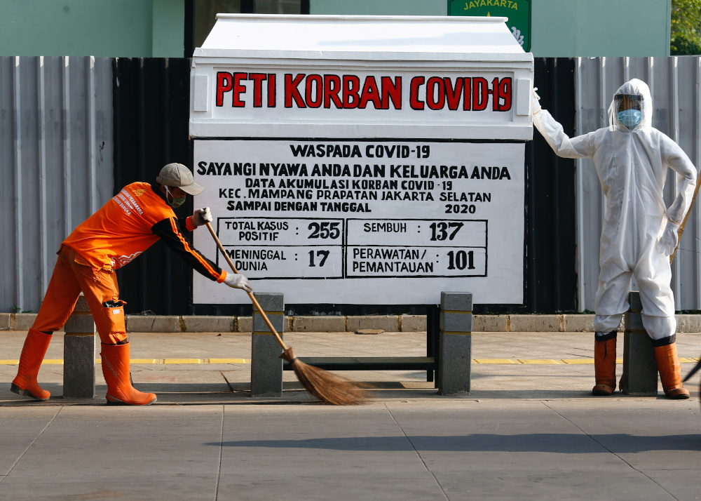 A worker sweeps near a mock coffin and a dummy dressed in a personal protective suit to resemble a health worker, in a public area to warn people about the dangers of the coronavirus disease in Jakarta, Indonesia, August 19, 2020. u00e2u20acu201d Reuters pic 