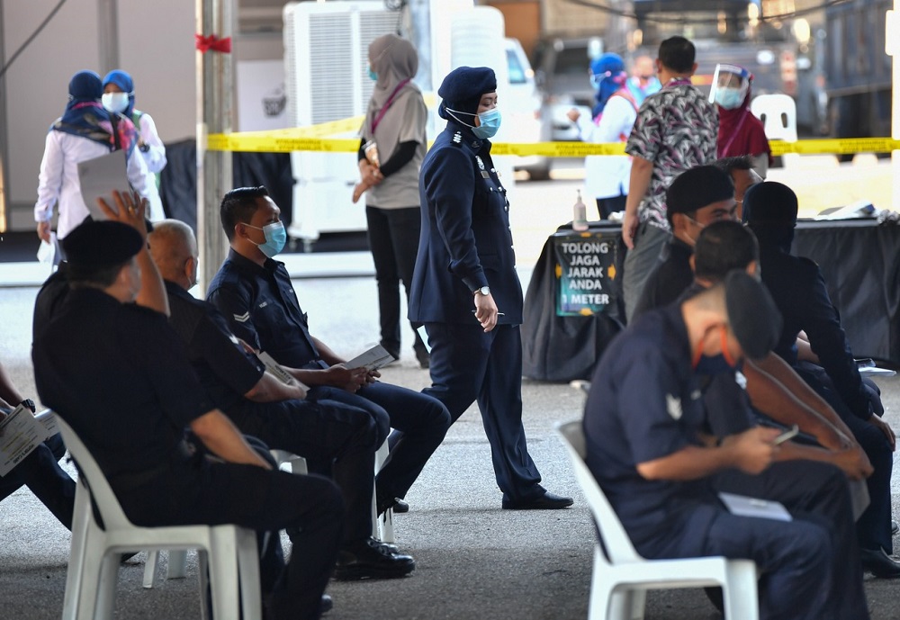 Police personnel observe social distancing as they cast their vote during the Slim by-election early voting in Tanjung Malim August 25, 2020. u00e2u20acu201d Bernama pic