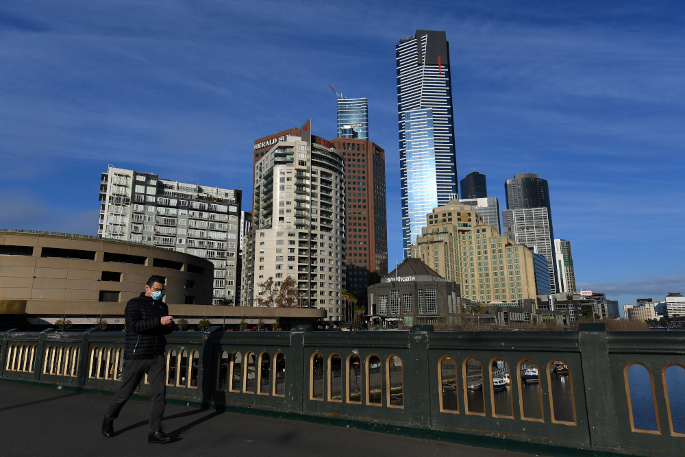 A person wearing a face mask walks across Princes Bridge as the city operates under lockdown restrictions to curb the spread of the coronavirus disease in Melbourne, Australia, August 3, 2020. u00e2u20acu201d AAP Image/James Ross pic via Reuters 
