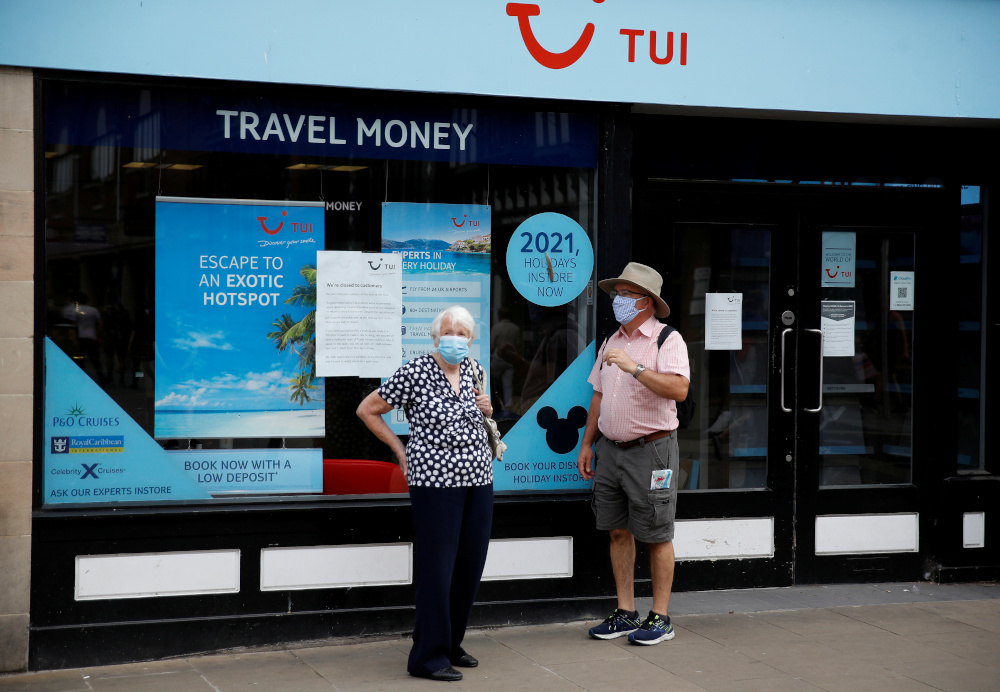 People wear face coverings as they stand outside a TUI travel agents shop following the outbreak of the coronavirus disease in Chester, Britain, August 10, 2020. u00e2u20acu201d Reuters pic 