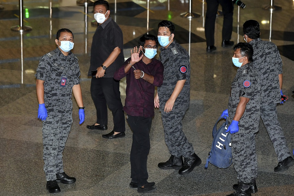 Md Rayhan Kabir diiringi pegawai Jabatan Imigresen Malaysia (JIM) kelihatan melambaikan tangan di KLIA sebelum berlepas pulang ke Bangladesh. u00e2u20acu2022 Foto Bernama