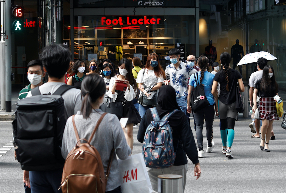 Shoppers wearing protective face masks cross a street in Singaporeu00e2u20acu2122s Orchard Road shopping district during the coronavirus disease outbreak in Singapore, August 17, 2020. u00e2u20acu201d Reuters picnnn