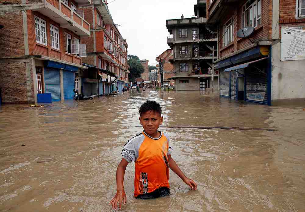 A boy walks along the flooded neighborhood after incessant rainfall in Bhaktapur, Nepal July 12, 2018. u00e2u20acu201d Reuters pic