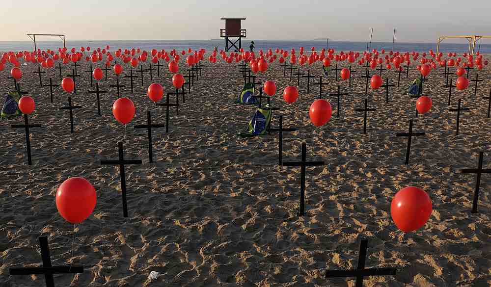 A woman jogs past crosses and balloons placed by members of the NGO Rio de Paz in tribute to the one hundred thousand Covid-19 deaths in Brazil, at the Copacabana beach in Rio de Janeiro August 8, 2020. u00e2u20acu201d Reuters pic