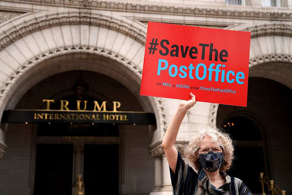 Erika Berg holds up a sign in support of the US Postal Service (USPS) outside the Trump Hotel in Washington August 22, 2020. u00e2u20acu201d Reuters pic 