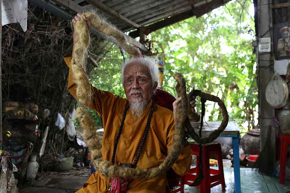 Nguyen Van Chien, 92, sits for a portrait to show his 5-meter long hair which, according to him, has not been cut for nearly 70 years, at his home in Tien Giang province, Vietnam August 21, 2020. u00e2u20acu201d Reuters pic