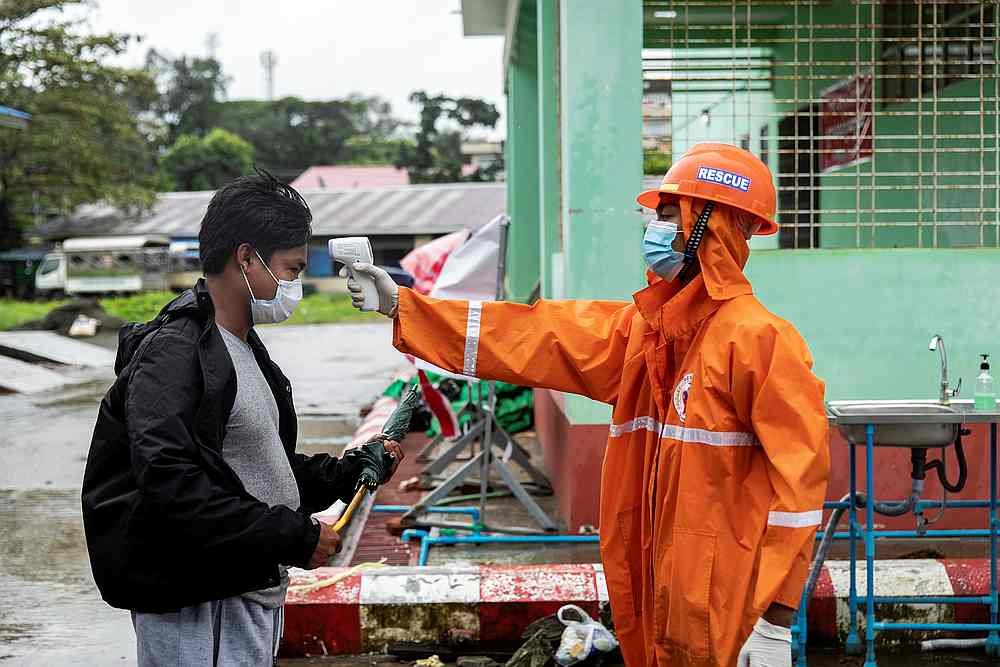 A volunteer checks the temperature of a man at the entrance of Sittwe Hospital, amid the Covid-19 outbreak, in Sittwe, Rakhine State, Myanmar August 24, 2020. u00e2u20acu201d Reuters picn