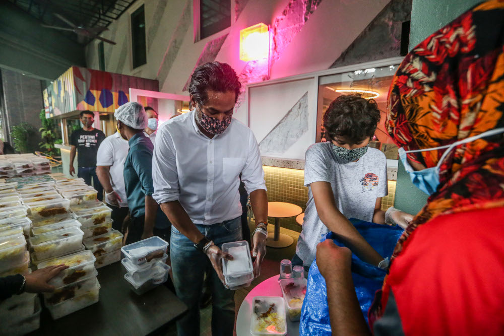Minister of Science, Technology, and Innovation Khairy Jamaluddin hands over meals for distribution during the ECM Libra Foundation and Pertiwi Covid-19 Food Aid Programme in Kuala Lumpur August 14, 2020. u00e2u20acu201d Picture by Firdaus Latif 