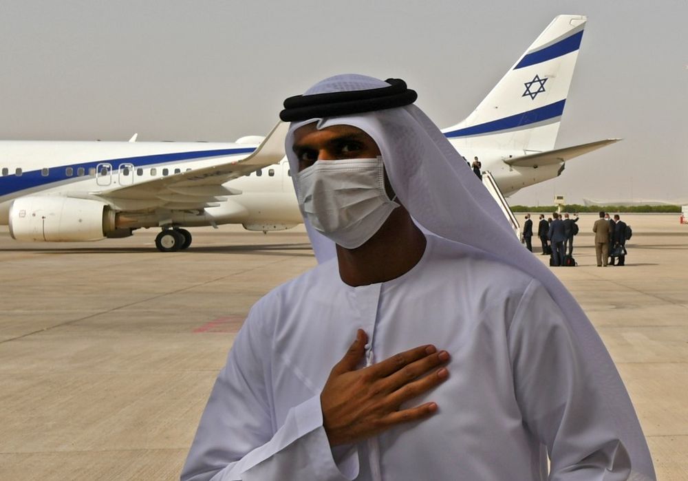 An Emirati official stands near an air-plane of El Al, which carried a US-Israeli delegation to the UAE following a normalisation accord, upon arrival at the Abu Dhabi airport in the first-ever commercial flight from Israel to the UAE, on August 31, 2020.