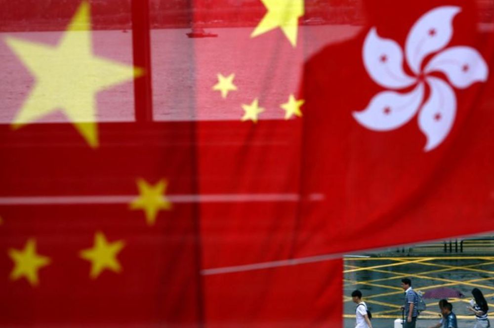 People walk past Chinese and Hong Kong flags after celebrations commemorating the 20th anniversary of Hong Kongu00e2u20acu2122s handover to Chinese sovereignty from British rule, in Hong Kong, China July 2, 2017. u00e2u20acu201d Reuters pic