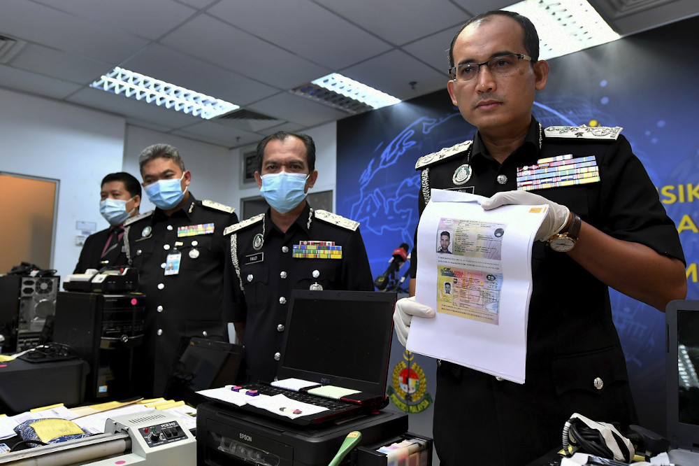 Immigration director-general Datuk Khairul Dzaimee Daud showing some of the items seized from the document forgery syndicates, in Putrajaya August 5, 2020. u00e2u20acu201d Bernama pic 