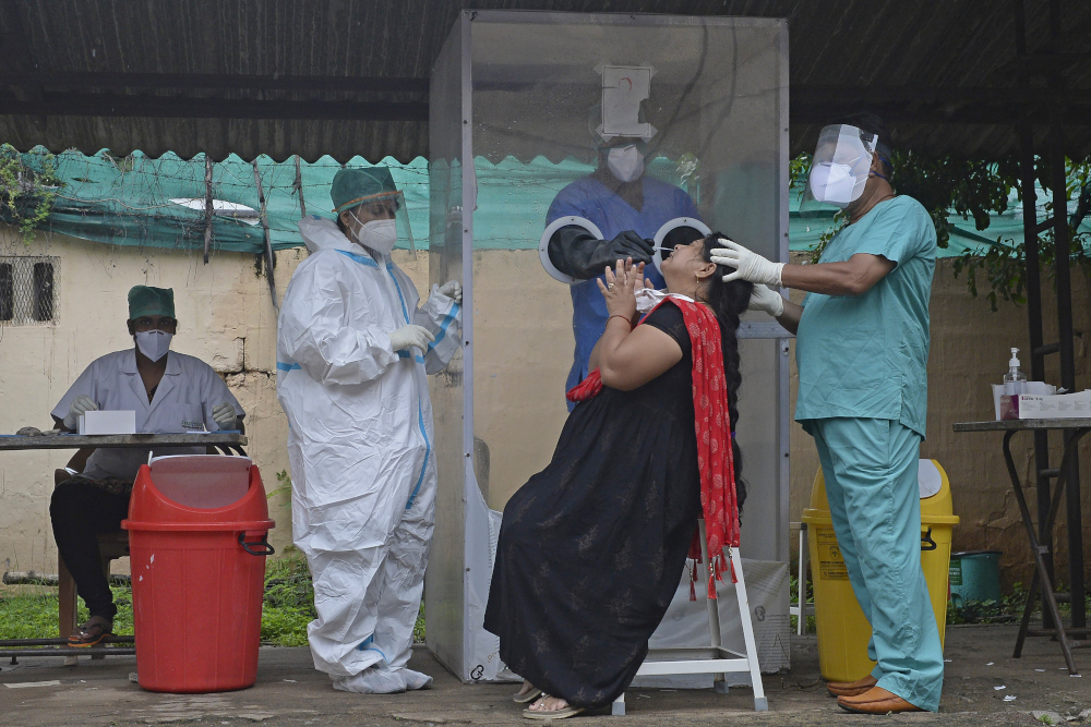 A health worker wearing personal protective equipment (PPE) gear collects a swab sample from a woman at a free Covid-19 coronavirus testing centre in Hyderabad August 19, 2020. u00e2u20acu201d AFP pic 