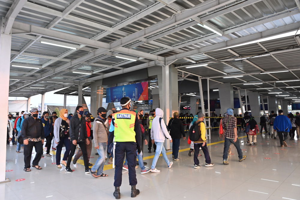Indonesians walk to get on a train bounds for Jakarta from Bogor station by applying protocols for the Covid-19 coronavirus in Bogor on August 3, 2020. u00e2u20acu201d AFP pic