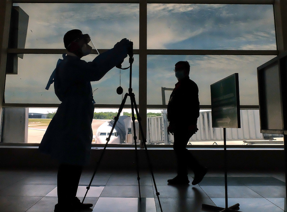 A Health Department Personnel setting up the Forward-Looking Infrared (FLIR) High Definition Thermal Camera for temperature screening at the arrival hall in Labuan Airport August 10, 2020. u00e2u20acu201d Bernama pic