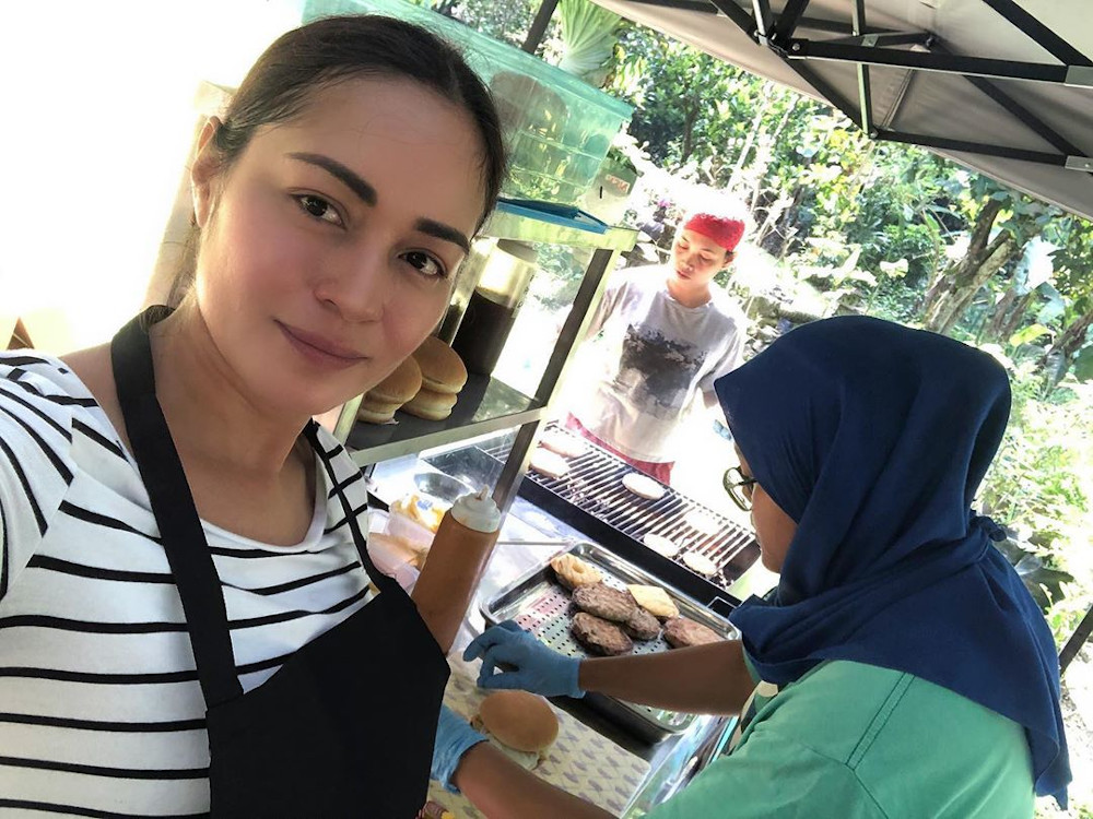 The u00e2u20acu02dcPontianak Harum Sundal Malamu00e2u20acu2122 star flipping burgers with a staff member in April. u00e2u20acu201d Picture from Instagram/Maya Karinn