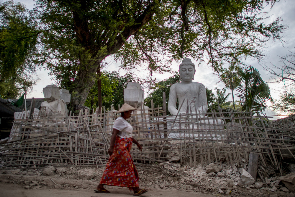 A woman walking past a marble statue in Sagyin village in Madaya township, Myanmar. u00e2u20acu201d AFP pic 