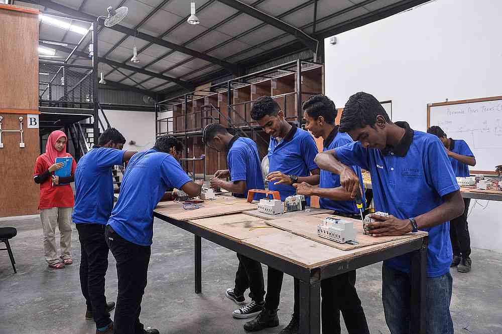Students working on their mini wiring projects during one of the lessons. — Picture by Miera Zulyana