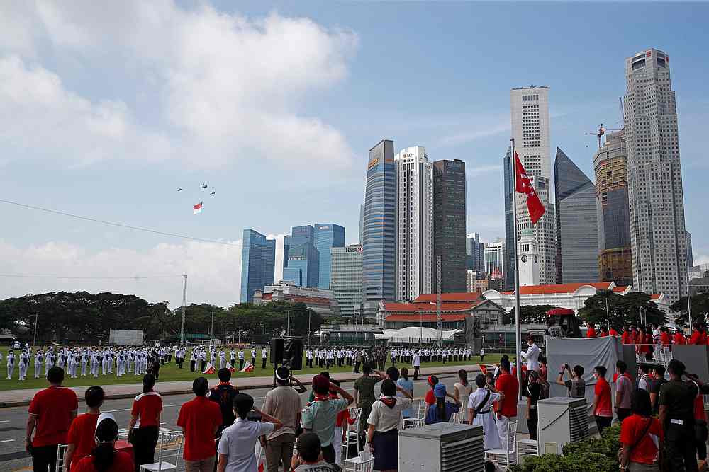 The state flag is flown as people stand for the national anthem during National Day celebrations, amidst the Covid-19 outbreak, in Singapore August 9, 2020. u00e2u20acu201d Reuters pic