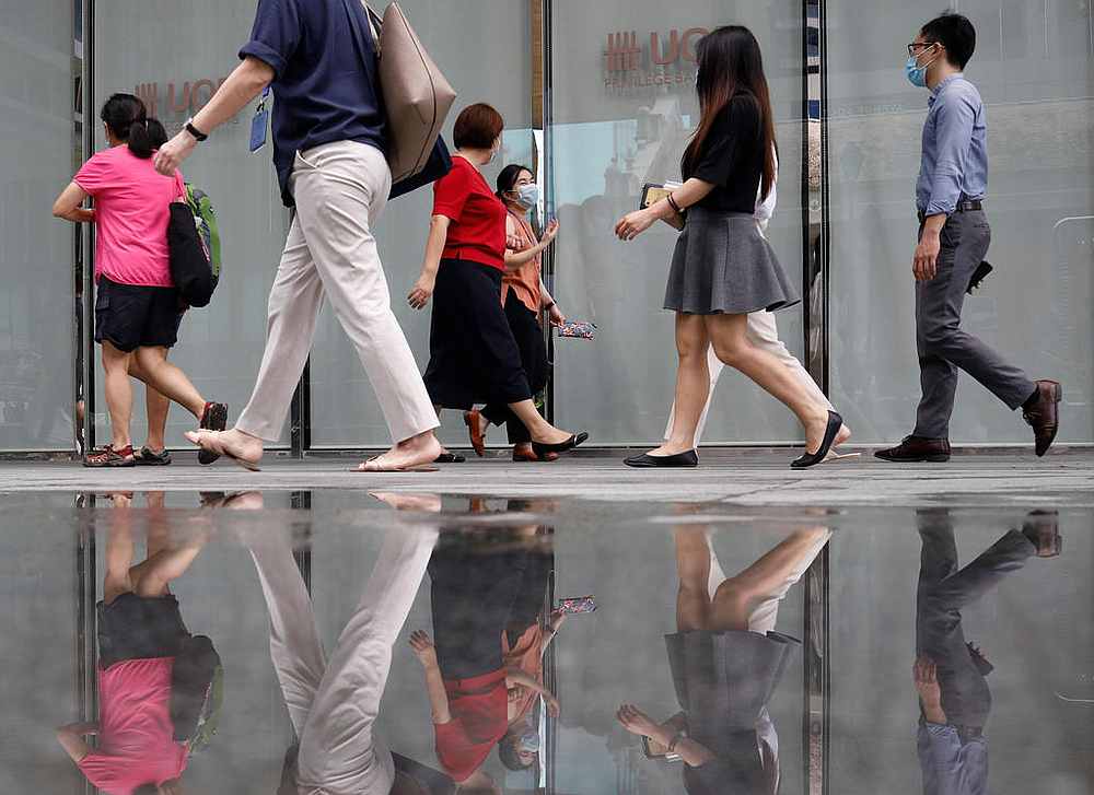Office workers wearing protective face masks walk in the central business district during the Covid-19 outbreak in Singapore. u00e2u20acu201d Reuters pic