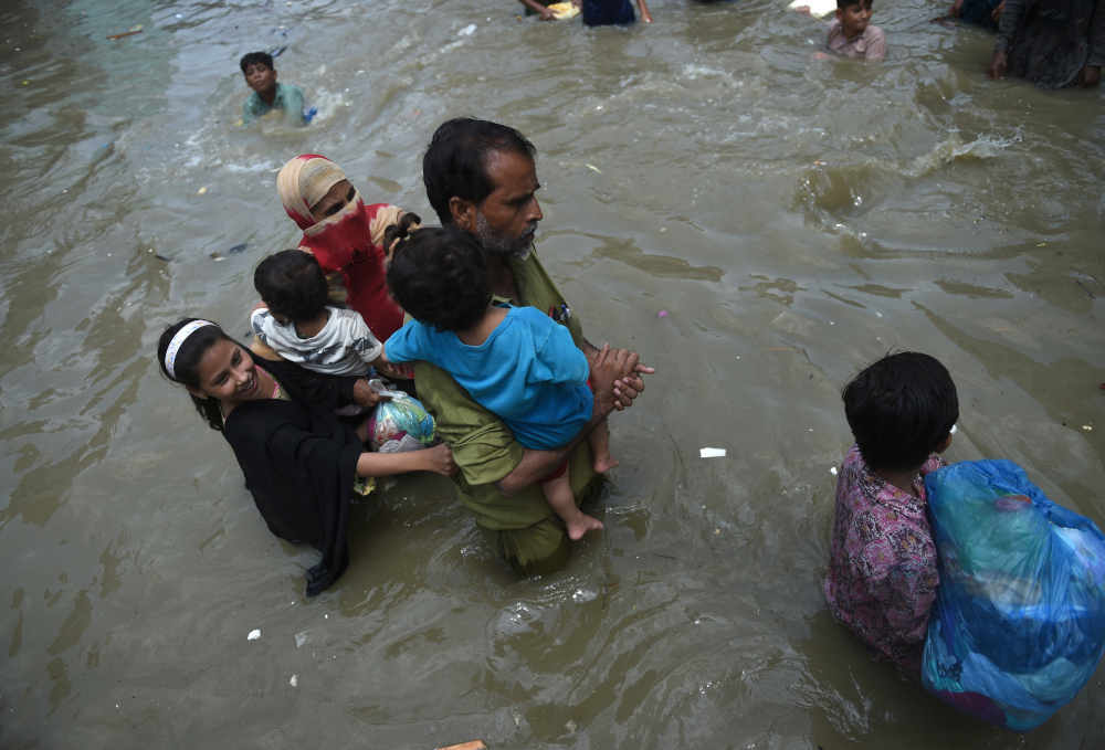 A family wades through a flooded street after heavy monsoon rains in the Pakistanu00e2u20acu2122s port city of Karachi August 22, 2020. u00e2u20acu201d AFP pic