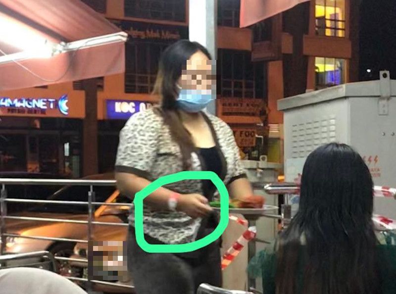 Picture of a woman sporting the pink Person Under Surveillance for Covid-19 wristband and dining out at a restaurant said to be in Ipoh, Perak were shared online today. u00e2u20acu201d Picture from social media