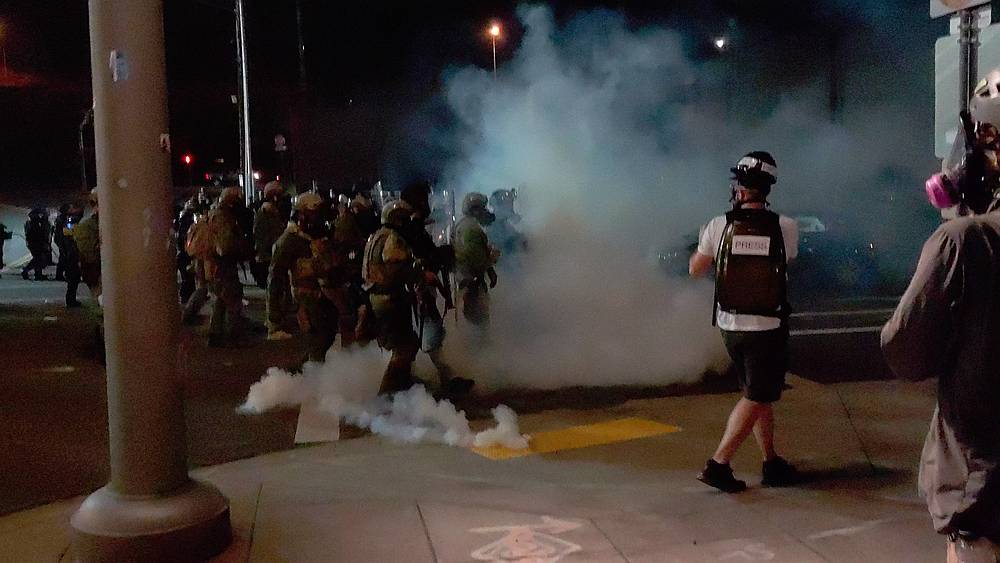 A member of the media stands amid tear gas used by police officers near an Immigration and Customs Enforcement centre in Portland, Oregon August 19, 2020. u00e2u20acu201d TWITTER/DAVE_BLAZER / INSTAGRAM/AARON2543 image via Reuters