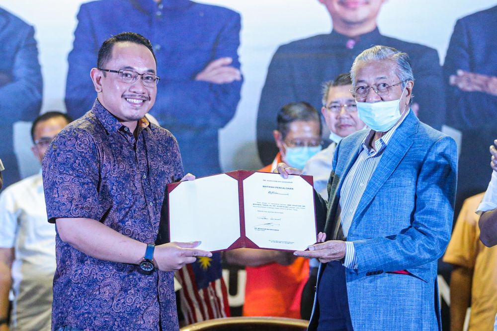 Tun Dr Mahathir Mohamad and Pejuang's candidate for the Slim by-election Amir Khusyairi Mohamad Tanusi (left) pose for the cameras in Tanjung Malim August 12, 2020. u00e2u20acu201d Picture by Hari Anggara
